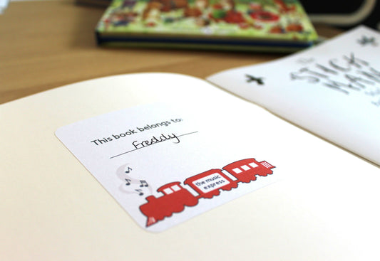 White bookplate with a red steam train and music notes coming out of the funnel. Text reads 'this book belongs to'